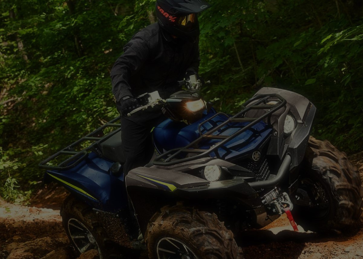 Bildet viser en ATV som kjører i skogen